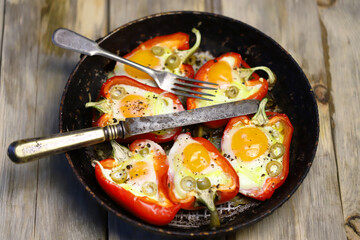 Selective focus. Red peppers with eggs baked in a frying pan. The keto diet. Keto lunch idea.