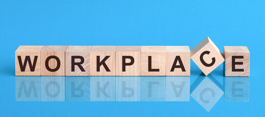 The text WORKPLACE is written on the cubes in black letters, the cubes are located on a blue glass surface.