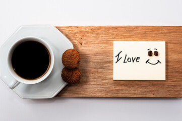 Hexagonal coffee cup on rustic wood on white background with the phrase: I LOVE. With space for text. Top view