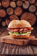 Bacon burger with firewood pile in background