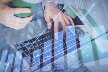 Double exposure of woman hands typing on computer and forex chart hologram drawing. Stock market...