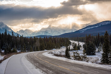 Fototapeta na wymiar Sunrays through cloudy skies seen from the Trans Canada Highway between Banff and Jasper. Alberta, Canada.
