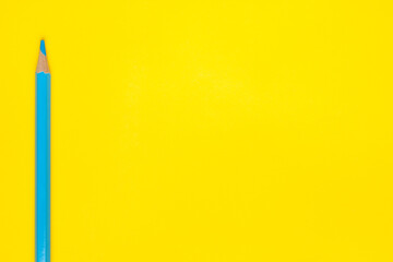 vertical blue sharp wooden pencil on a bright yellow background, isolated, copy space, mock up.