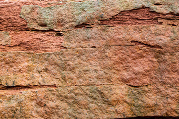 Lovely patterns and textures of a colorful red sandstone rock on the beach of Prince Edward Island.