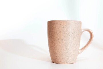 Gently cream colored cup on a white background.