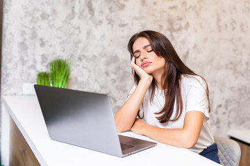Fototapeta na wymiar Felt asleep at home. Attractive young woman sleeping near her laptop at home