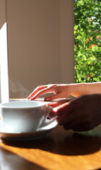 Woman working at home with laptop and a hot water drink