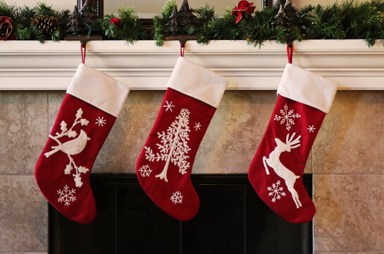Three red christmas stockings on fireplace mantle