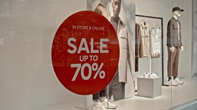 text on the red sticker on the glass of window in the store with the inscription sale up to 70% off