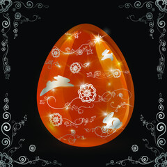 Shiny orange ornate Easter egg with silver ornament with hares on a black background.