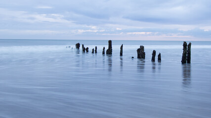 Old wooden posts into the sea