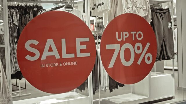 text on the red sticker on the glass of window in the store with the inscription sale up to 70% off