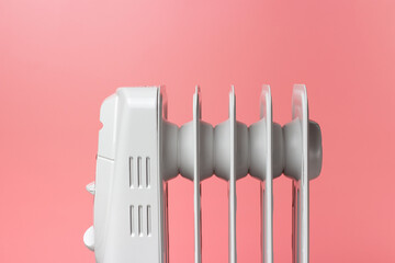 Gray electric heater on a pink background close-up.