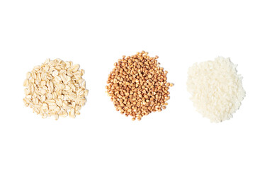 Small piles of rice grains, buckwheat and oatmeal on white background