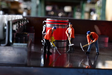 Miniature Workers on Sheet Metal Stamping Tool Die for Automotive Precision Parts on the Numerical Control Milling Machine Table. Tandem Stamping System. At a High Quality Technology Factory.