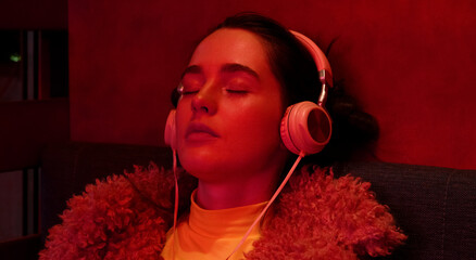 Fashionable woman delighting in music with headphones in cafe