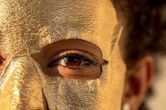 Woman applying golden face mask
