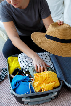Anonymous woman preparing luggage for vacation