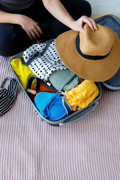 Anonymous woman packing suitcase at home