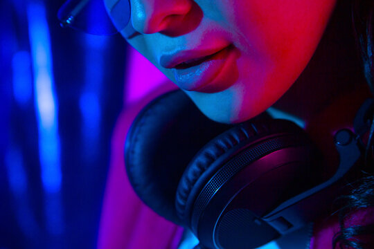 Young woman with headphones in neon light