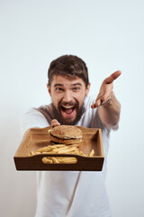 man with wooden tray fries and hamburger fast food calories model white t-shirt