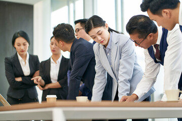 group of asian corporate executives meeting in office discussing business plan