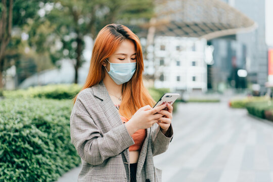 Young business woman wearing medical protective mask on the street