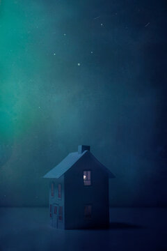 A little paper house sits under a night sky filled with stars and meteors