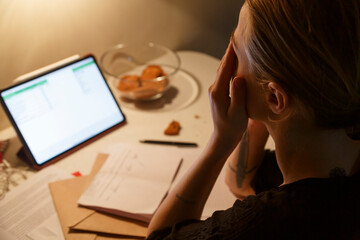 Overworked female freelancer rubbing face