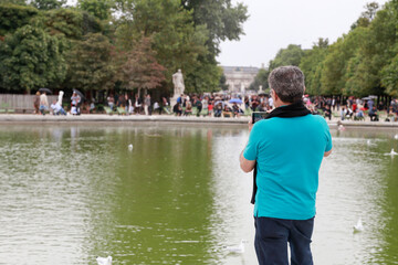 Fototapeta premium Man taking photos in a park in Paris.
