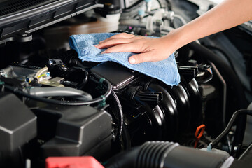 hand of a man holding a blue cloth caring, maintenance car and cleaning And engine car room.Hand focus selection