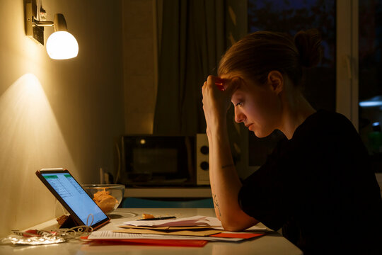 Tired woman working with papers at night