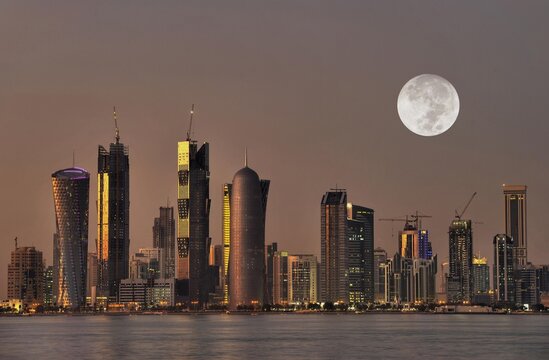 Twilight shot, Doha skyline with the Tornado Tower, Navigation Tower, Peace Towera, Al-Thani Tower and the moon, Doha, Qatar, Persian Gulf, Middle East, Asia