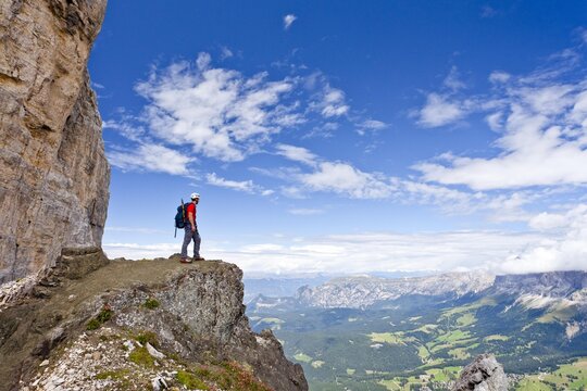 Climber crossing the Latemar mountains, fixed rope route, Dolomites, behind the Rosengarten group, South Tyrol, Italy, Europe