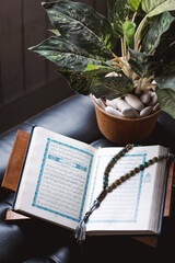 The holy Quran and rosary or tasbih on minimalist black interior