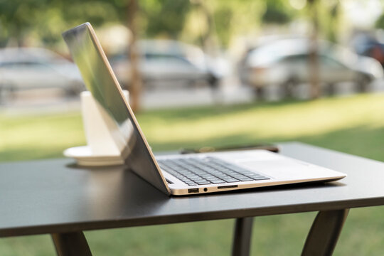 Close-up of laptop on table at sidewalk cafe