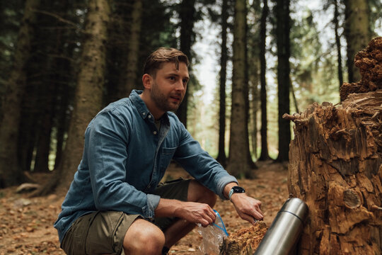 Male biologist looking away while taking samples in forest