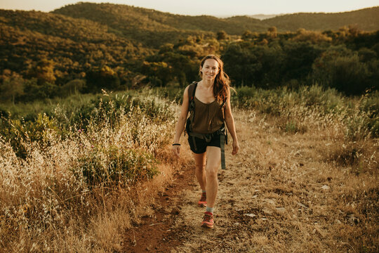 Adventurous woman walking in forest during sunset