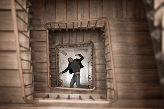 Directly above view of young man fallen down from staircase on floor