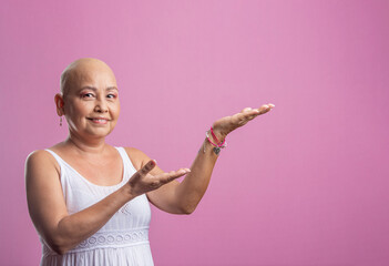 Mujer con cáncer de mama en fondo rosado