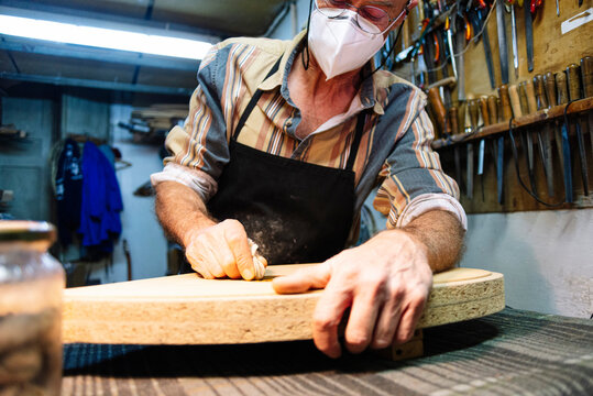 Instrument maker making lute at workshop