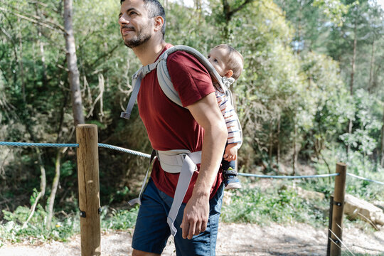 Father hiking with his children, carrying son on his back