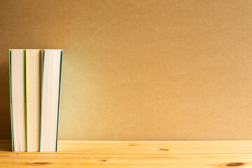 Books on wooden desk with brown background