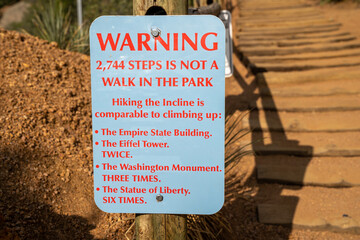 Warning sign at the base of the Manitou Incline hike in Colorado, reminding hikers that this is a difficult hike up the stairs
