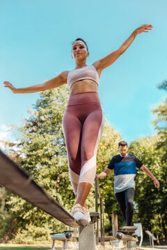 Woman balancing on slackline on a fitness trail