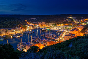 France, Corse-du-Sud, Bonifacio, Illuminated harbor of coastal town at night