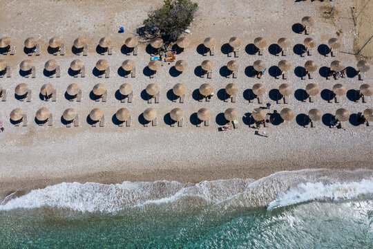 Rows of deck chairs and beach umbrellas along Potami Beach in summer