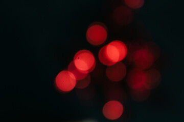 red bokeh on a black background, out of focus, red background, blurry background, round lights in...