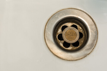Turkish kurus coin is thrown away in dirty sink. Turkish lira and Turkish economy collapse concept. Copy space. Top view