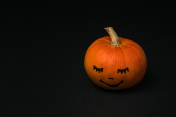 Pumpkin with a face in bright light on a black background.